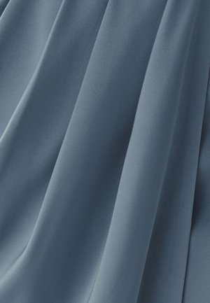Mekana, lepršava tkanina u prigušenoj plavoj nijansi, sa glatkom teksturom i nježnim naborima, blago sjajna.