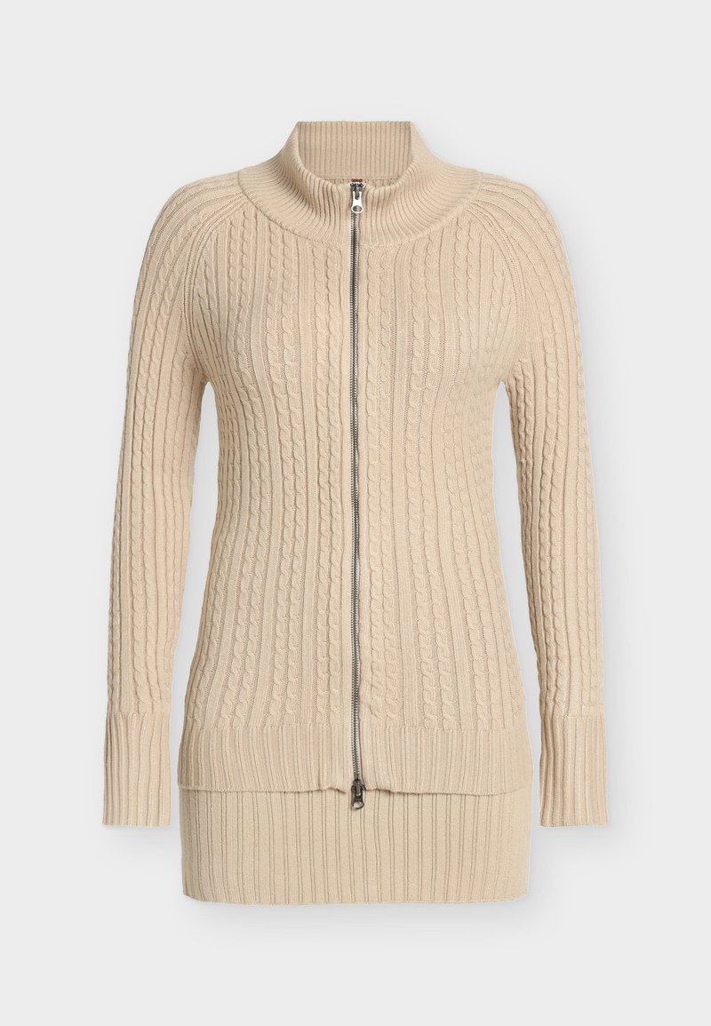 Beige stickad tröja med hög krage och hel dragkedja, med kabelstickade mönster samt ribbstickade muddar och fåll. Mjuk textur.