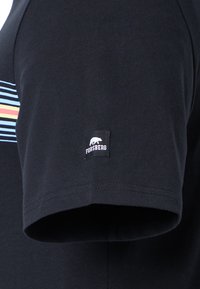 Schwarzes Baumwoll-T-Shirt mit bunten Streifen und einem kleinen schwarzen "Forsberg"-Logopatch am Ärmel. Sanfte Textur. Kurzarmdesign.