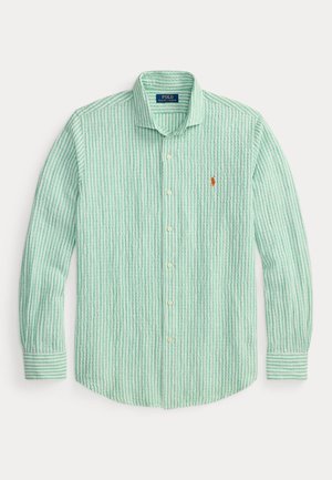 Chemise à manches longues à rayures verticales vert clair et blanc, avec col et petit logo orange brodé sur la poitrine.
