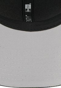 Schwarze und graue Cap mit flacher Krempe, die einen strukturierten Stoff und eine glatte Unterseite aufweist. Enthält ein Herstelleretikett am inneren Band.