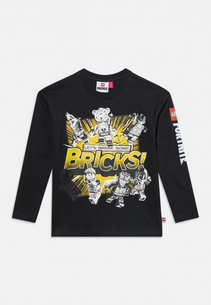 Chemise noire à manches longues avec des personnages LEGO Fortnite et le texte "Let's break some bricks!" en jaune et blanc sur le devant.