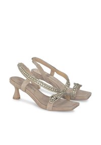 Sandalias de ante beige con tacón bajo, que presentan correas entrelazadas adornadas con brillantes plateados y una plantilla texturizada.