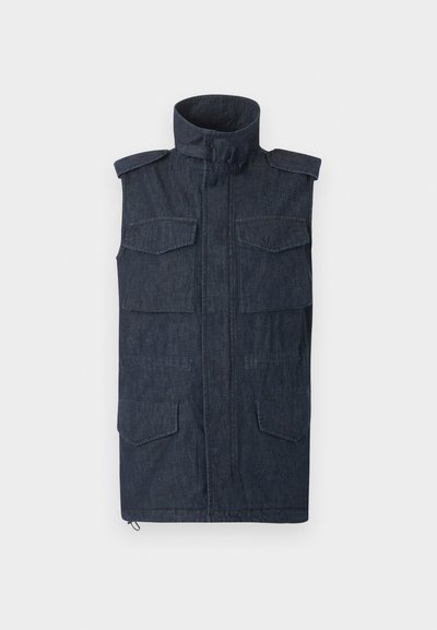 Αμάνικο σκούρο τζιν γιλέκο με ψηλό γιακά, φερμουάρ μπροστά, επιθεματάκια στους ώμους και τέσσερις τσέπες με καπάκι μπροστά.