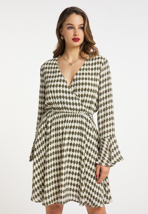 Der floral gemusterte Wickelkleid in Creme mit schwarzen und goldenen Rautenmotiven. Verfügt über einen tiefen V-Ausschnitt, lange Glockenärmel und einen elastischen Bund.