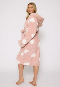 Bata de baño con capucha de color rosa, hecha de suave forro polar, con patrones de corazones blancos, una cintura con cinturón y puños texturizados en contraste.