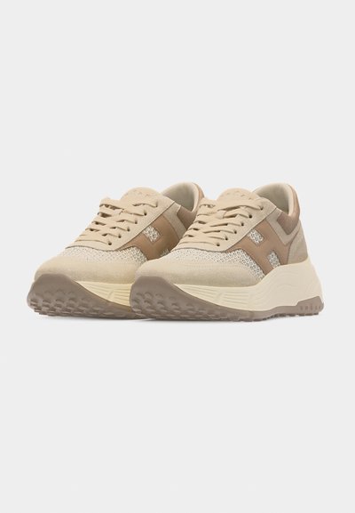 Paire de baskets beige et marron clair à lacets avec semelles texturées et dessus en daim et mesh, vue avant en angle sur fond blanc.