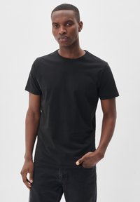 Tricou negru cu guler rotund, mânecile scurte, fabricat din bumbac fin. Design ușor ajustat, fără modele sau accente vizibile.