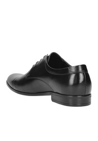 Scarpe eleganti in pelle nera con finitura liscia, punta arrotondata, design con lacci, tacco basso e dettagli di cucitura discreti sui lati.