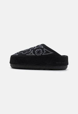 Sorte suede slip-on sko med broderet design, rund tå, tyk sål og teksten "MOON BOOT" på hælen. Struktureret overflade.