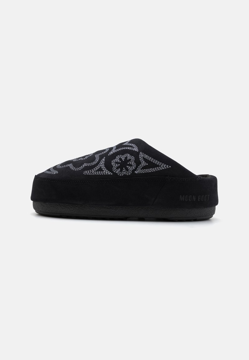 Zwarte suede instap schoenen met geborduurd ontwerp, ronde neus, dikke zool en de tekst "MOON BOOT" op de hak. Structuur oppervlak.