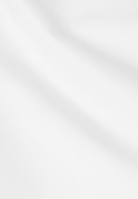 Humo marrón desvaneciéndose que se eleva desde una motocicleta encendida que circula por un parque con árboles verdes y luz solar de fondo.