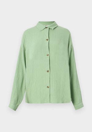 Svetlozelena srajca s ovratnikom in gumbi, izdelana iz teksturirane tkanine, dolge rokave in rjave gumbe spredaj. Priložnostna prileganje in mehak zaključek.