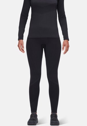 Svart langermet topp og figurnære svarte leggings laget av elastisk stoff; har et teksturert mønster og subtile designakenter.