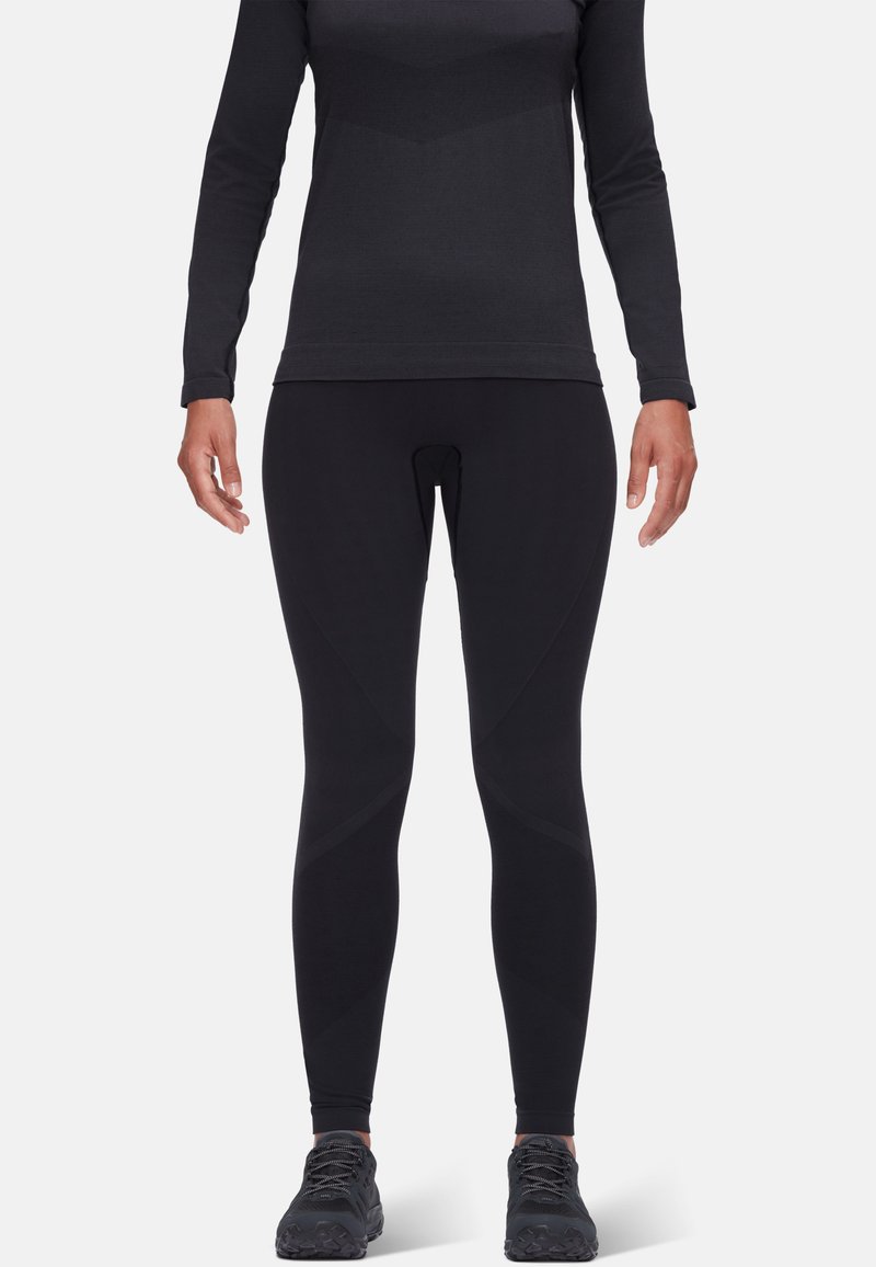 Svart langermet topp og figurnære svarte leggings laget av elastisk stoff; har et teksturert mønster og subtile designakenter.