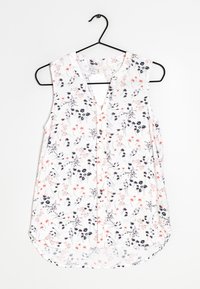 Floral sleeveless blouse with a V-neckline, featuring a white background, black and red flower patterns, and a curved hemline.