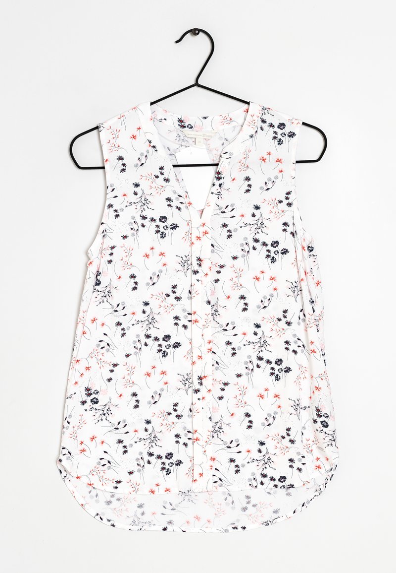 Floral sleeveless blouse with a V-neckline, featuring a white background, black and red flower patterns, and a curved hemline.