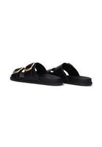 Black slide sandals with a flat sole, featuring two wide straps and large circular gold hardware accents. Smooth matte texture.