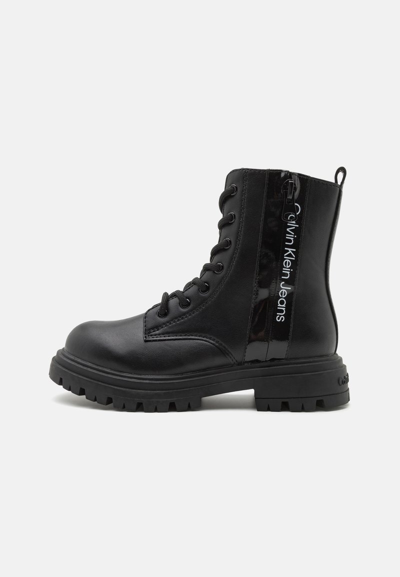 Black combat boots featuring a smooth leather upper, lace-up front, rubber outsole, and side zipper with logo detailing.