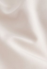 Smooth, light beige fabric with a subtle texture, draping softly to reveal a plain surface without patterns or accents.