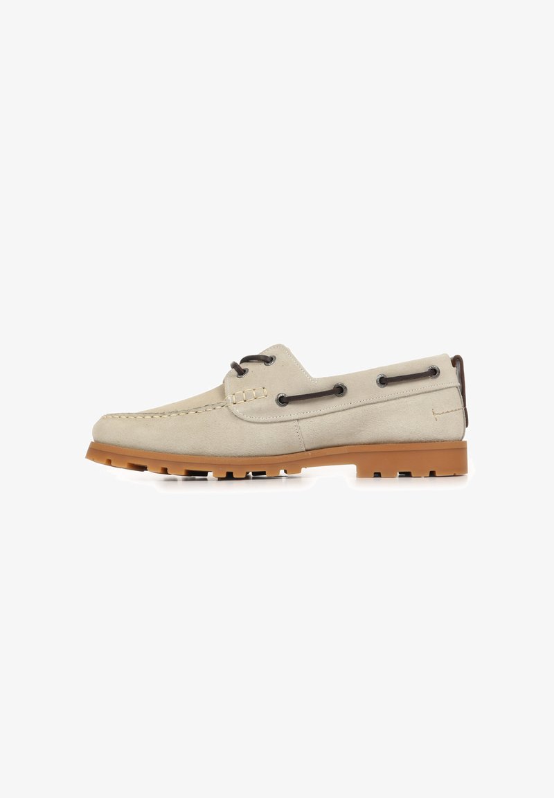 Chaussure bateau en daim beige avec des lacets marron et une semelle en caoutchouc marron clair, vue latérale sur fond blanc.