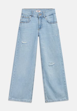 Jasnoniebieskie dżinsy o szerokich nogawkach z zapięciem na guziki i zamek, kieszeniami z przodu i z tyłu oraz przetartymi łatami na udach.