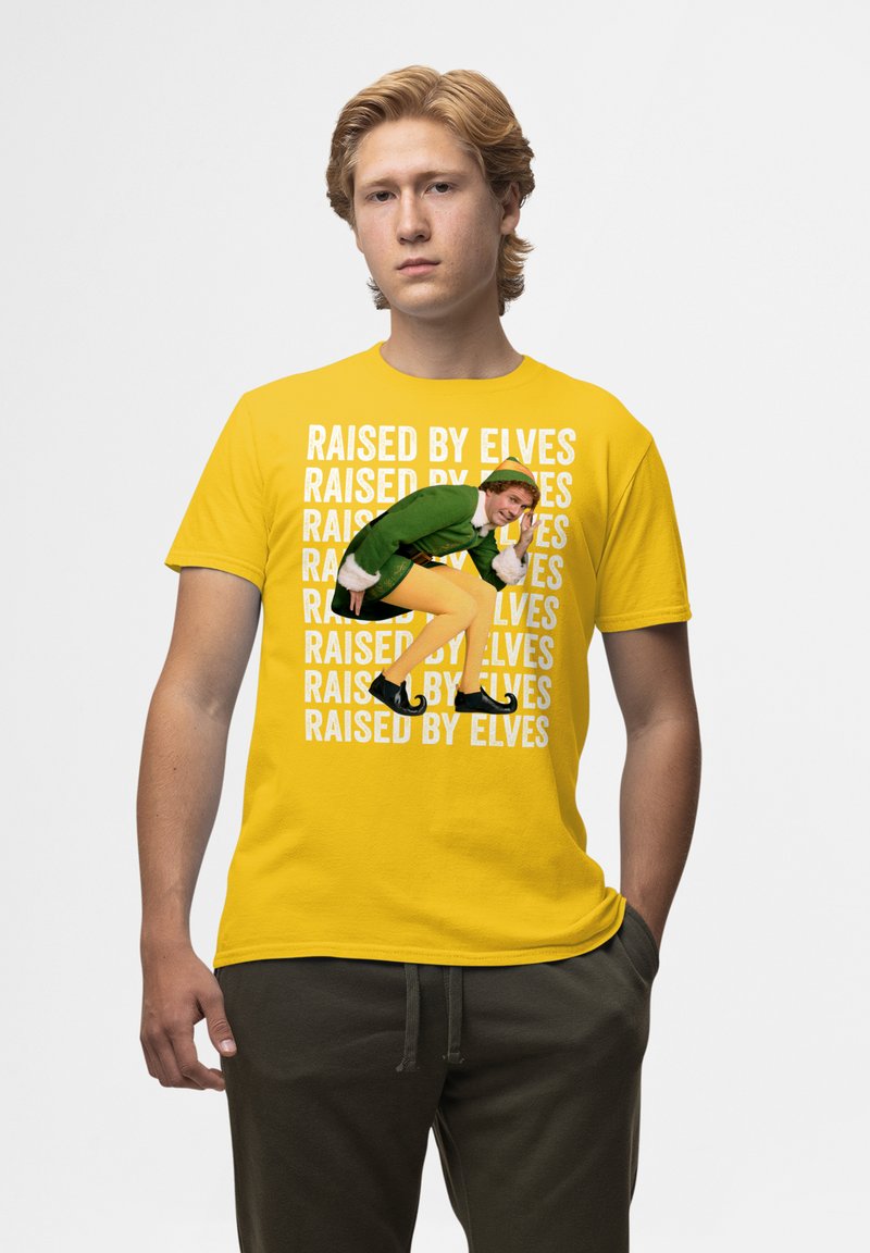 Camiseta de algodón amarilla que presenta el texto "CRIO POR ELFOS" en un patrón repetido en blanco, con un gráfico impreso de un personaje vestido con un atuendo verde.