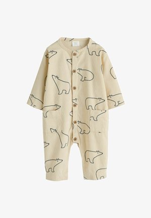 Combinaison pour bébé en tissu beige doux, ornée d'un motif répétitif d'ours noir. Elle a des manches longues, une fermeture à boutons et deux poches avant.