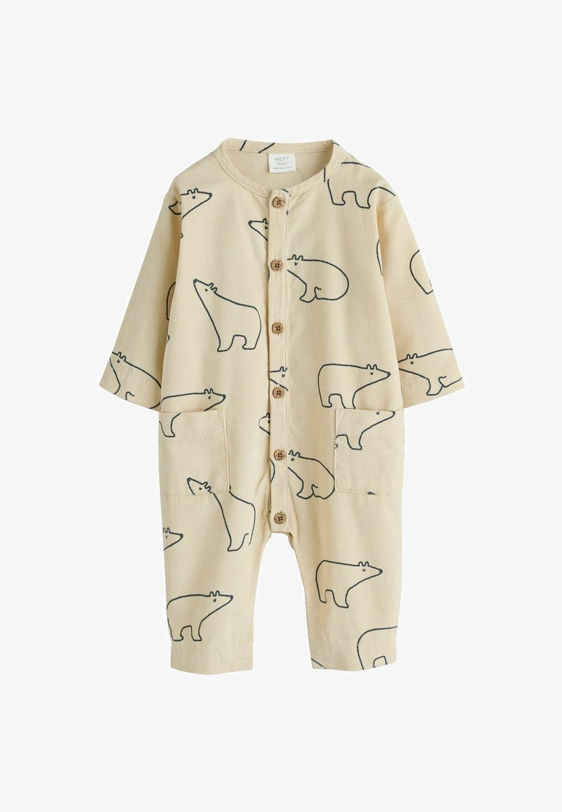 Combinaison pour bébé en tissu beige doux, ornée d'un motif répétitif d'ours noir. Elle a des manches longues, une fermeture à boutons et deux poches avant.