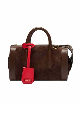 Sac à main en daim et cuir marron avec des poignées arrondies, des ferrures dorées, et une étiquette en cuir rouge étiquetée "Lancel" attachée à une poignée.
