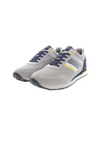 Scarpe sportive grigie realizzate in suede e tessuto a rete, dotate di lacci blu navy, accenti gialli e una suola in gomma testurizzata con un design semplice.