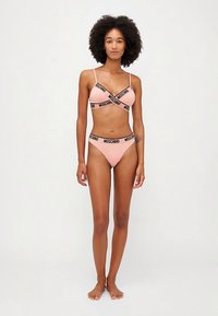 Pink lingerie set with black "Moschino" branding. Includes a triangle bralette with thin straps and matching bikini-style bottom.