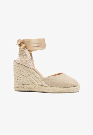 Espadrillas beige con zeppa e tacco in juta intrecciata, punta chiusa e nastrino da legare alla caviglia.