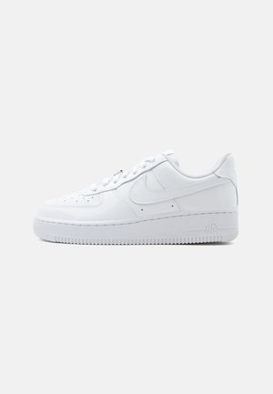 Hvit lavtopp Nike Air Force 1-sneaker med snøring, perforert tåboks og det karakteristiske swoosh-logoen på siden.