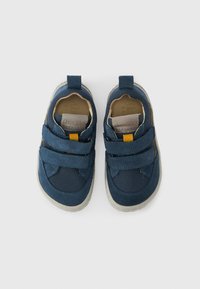 Μπλε υφασμάτινα παπούτσια με λουράκια Velcro, φωτεινές γκρι σόλες α πό καουτσούκ και υφή δίχτυ στο πάνω μέρος. Περιλαμβάνει θηλιά τραβήγματος στο πίσω μέρος.