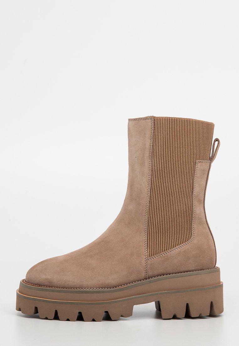 Wildleder-Stiefelette in Hellbraun mit gerippten elastischen Seitenpaneelen, einer Zuglasche und einer klobigen, strukturierten Gummisohle.