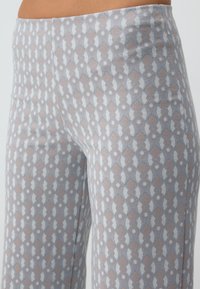 Leggings légers à motifs en gris clair et beige, dotés d'un motif en losange, avec une texture lisse et une taille élastique.