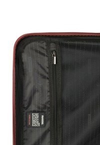 Binnenspiegel van een rode reistasje met zwarte voering, voorzien van een gaasvak, een ritscompartiment en een merklabel op de stof.