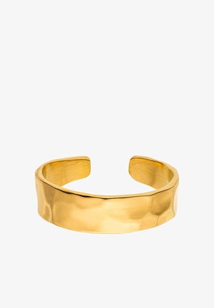 Wide, open-ended gold cuff bracelet with a smooth, slightly hammered texture and a shiny finish on a white background.