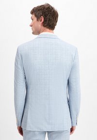 Hellblau kariertes Sakko mit strukturiertem Finish, ausgestattet mit einem Schmetterlingsschlitz und knopfbaren Manschetten. Von hinten betrachtet.