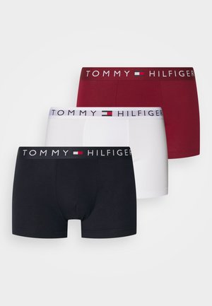 Zestaw trzech bokserek w kolorach czarnym, białym i burgundowym, z elastycznym paskiem z logo "TOMMY HILFIGER" w wyraźnym druku.