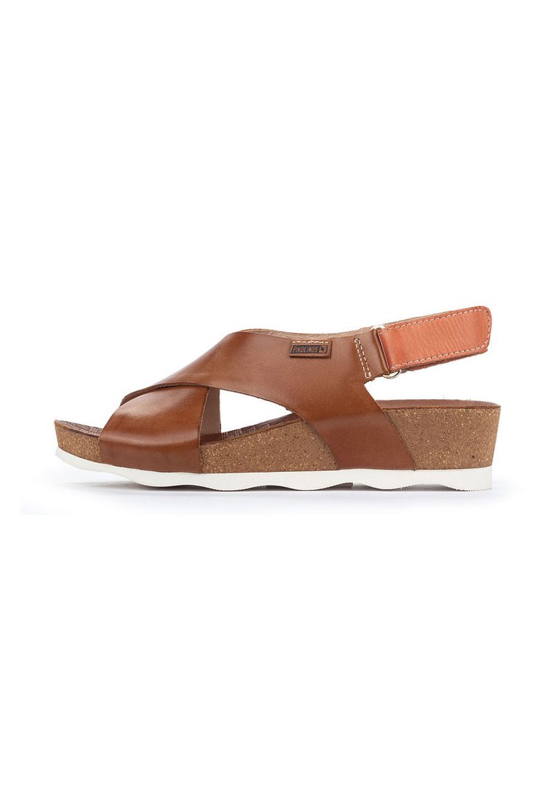 Sandali in pelle marrone con design della parte superiore incrociato, suola intermedia in sughero e suola esterna in gomma bianca. Cinghia posteriore regolabile per una vestibilità sicura.