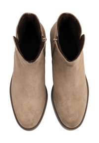 Une paire de bottines en daim beige avec une doublure intérieure marron foncé, vues de dessus, montrant des fermetures éclair latérales et des bouts ronds.