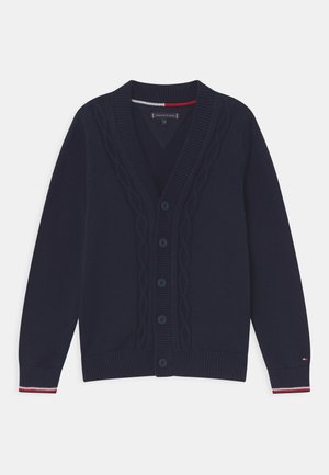 Marineblauer Strickcardigan mit V-Ausschnitt, Zopfmuster, sechs Knöpfen zum Schließen und gerippten Bündchen mit roten und weißen Streifen.