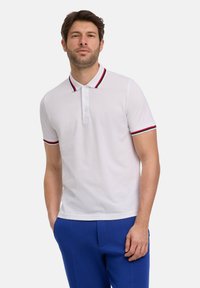 Biała koszulka polo z prążkowanym kołnierzykiem z czerwonymi i niebieskimi paskami, krótkie rękawy z dopasowanymi akcentami i slim fit.