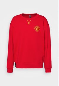 Felpa rossa con maniche lunghe, polsini a coste, scollo rotondo e logo ricamato giallo del Manchester United sul petto.