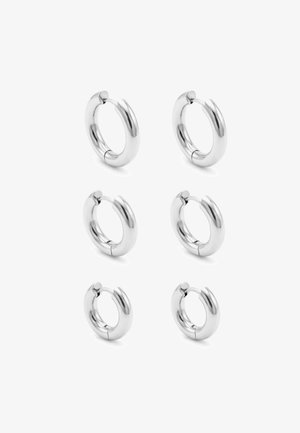 Trois paires de boucles d'oreilles créoles en argent brillant en petites, moyennes et grandes tailles, disposées en deux colonnes sur fond blanc.