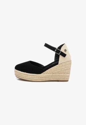 Zapato de cuña espadrille negro con punta redondeada, parte superior de textil, tira en el tobillo y plataforma de yute trenzado. Detalle a cuadros en el talón.