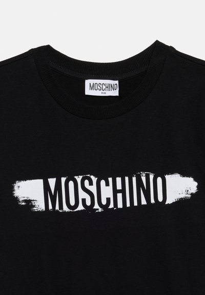 Μαύρο παιδικό μπλουζάκι Moschino με λευκό γραφικό πινελιάς πινέλου πίσω από το έντονο κείμενο Moschino μπροστά.