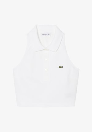 Witte cropped poloshirt zonder mouwen met kraag, drie knopen en klein groen geborduurd Lacoste krokodillenlogo op de borst.
